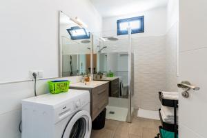 une salle de bains avec lave-linge et lavabo dans l'établissement Enchanting and centric flat - Puerto de la Cruz, à Puerto de la Cruz 30 autres photos
