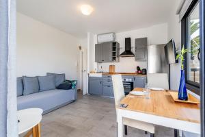 une cuisine et un salon avec une table et un canapé dans l'établissement Enchanting and centric flat - Puerto de la Cruz, à Puerto de la Cruz