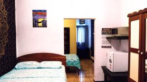 ein kleines Schlafzimmer mit Bett und Küche in der Unterkunft Maxroomz in San Ignacio