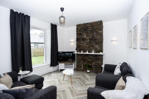 a living room with two couches and a fireplace at Devon Hot Tub Retreat in Bideford +33 photos