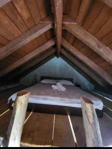 a bed in the attic of a wooden building at Miki's Little House in Supetar