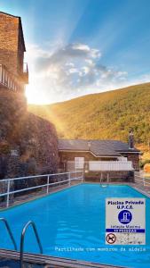 a swimming pool with a sign in front of a building at Égua Nature House in Piódão