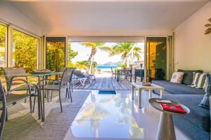 a living room with a couch and a table at Cottage Beach House NBBC 2, beachfront, pools in Baie Nettle +22 photos