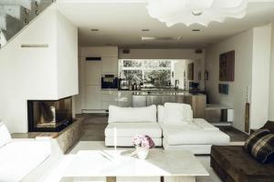 a living room with two white couches and a fireplace at Luxe Design Dreamscape in Lidingö