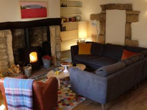 a living room with a couch and a fireplace at Little Brook Cottage in Hebden