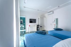 two beds in a white room with blue pillows at Napoli 164 in Castellammare di Stabia +88 photos