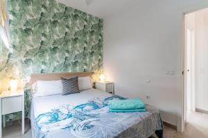 une chambre avec un lit avec un mur d'accent floral dans l'établissement Modern and comfortable apartment - Center Puerto, à Puerto de la Cruz