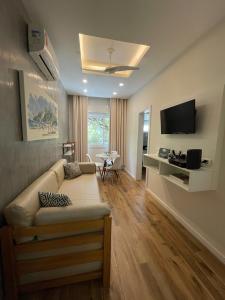 Una sala de estar con un sofá y un televisor de pantalla plana. en Apartamentos em Ipanema, en Río de Janeiro