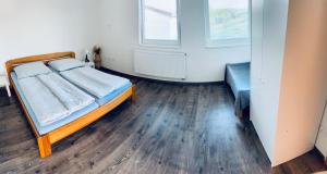 a bedroom with a bed and a wooden floor at Apartmán Lilly in Borovany