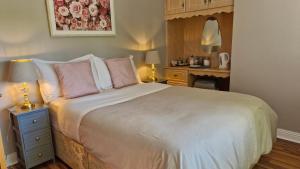 a bedroom with a bed with pink pillows and a desk at The Yoke B&B and Self-Catering Accommodation Laois in Ballybrittas