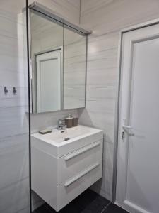 Un baño con un lavabo blanco y un espejo. en Apartments Nuro, en Ulcinj 65 fotos más