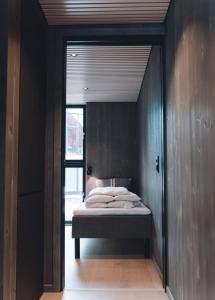 a bedroom with a bed in a room with black walls at Seafront apartment Henningsvær in Henningsvær
