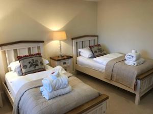 ein Schlafzimmer mit zwei Betten mit Handtüchern darauf in der Unterkunft Ben Lawers Rest Cabin - Hot Tub and Loch Tay Vistas in Lawers
