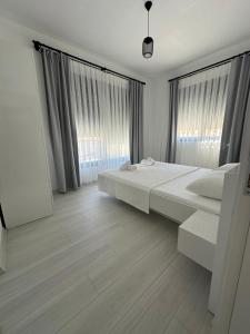 a white bedroom with a bed and two windows at Doğan Homes Likya in Demre +15 photos