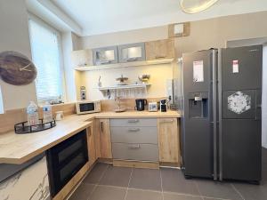 a kitchen with a stainless steel refrigerator and wooden counters at L'oasis citadine in Nevers