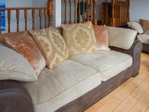 a couch with pillows on it in a living room at Bayview Cottage in Penzance