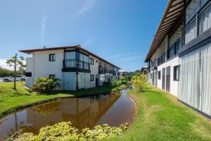 a canal between two buildings next to a street at VLP - Apartamentos próximos à Praia do Forte/BA in Mata de Sao Joao