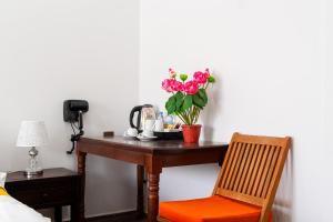 a table with a vase of flowers and a chair at 855 Villa in Siem Reap