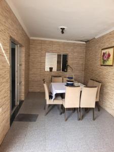 a dining room with a table and chairs at Linda casa para final de semana com churrasqueira in Praia Grande +3 photos