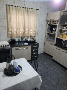 a kitchen with a table and a counter top at Linda casa para final de semana com churrasqueira in Praia Grande