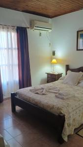 a bedroom with a bed with a lamp and a window at Las Gemelas 3 - Villa Elisa in Villa Elisa