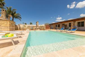 una piscina con dos sillas y una casa en Tenuta Doret, en Taviano