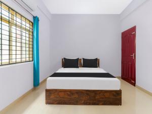 a bedroom with a bed and a window at Hotel O NILA TOURIST HOME in Trivandrum