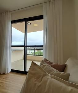 a bedroom with a bed and a large window at Mogi das Cruzes: Perto de Tudo, Conforto Total in Mogi das Cruzes +42 photos