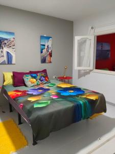 a bedroom with a large bed with a colorful comforter at Vistas al mar 2 in Tías
