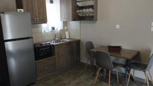 Una pequeña cocina con una mesa y un refrigerador. en Oneiropetra 3, en Mouzákion 13 fotos más