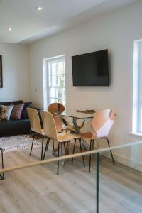 Una sala de estar con una mesa de cristal y sillas. en Merthen House, en Falmouth