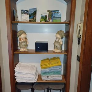 a book shelf with two dolls and towels at B&B Miele in San Fermo della Battaglia