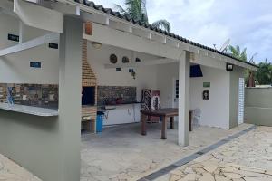 a patio with a wooden table under a pergola at Casa na Morada da Praia - Q83 in Bertioga