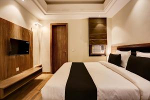 a bedroom with a large bed and a flat screen tv at Super Collection O Stargaze in Kānpur