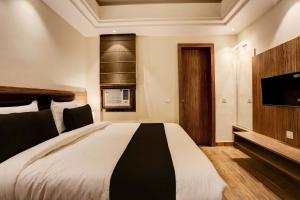 a bedroom with a bed and a flat screen tv at Super Collection O Stargaze in Kānpur