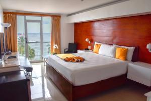 a bedroom with a large bed with a wooden headboard at Napolitano Hotel in Santo Domingo