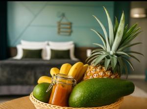 a basket of fruit with a pineapple and a jar of salsa at Archipel Guadeloupéen - Entre grand balcon, piscine & lagon - Élégant cocon d'architecte 2 étoiles in Saint-François