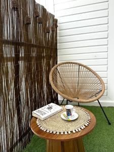 a coffee table with a book and a cup of coffee at Archipel Guadeloupéen - Entre grand balcon, piscine & lagon - Élégant cocon d'architecte 2 étoiles in Saint-François