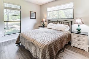 a bedroom with a bed and two windows at Canyon Lake House with Porch, Views and Private Gazebo in Canyon Lake +34 photos