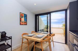 une salle à manger avec une table et des chaises et une fenêtre dans l'établissement 3BR Portview Luxury Penthouse & Terrace, à Las Palmas de Gran Canaria