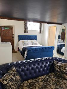 a bedroom with a blue bed and a couch at Luxury Retreat, Children and Dogs too in Bridgwater