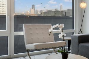 a white chair sitting in front of a window at Chic 4-Bedroom with Skyline Views & Amenities in Chicago