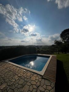 a swimming pool in a yard with the sun in the sky at Casa em La Palma Hotel Fazenda in Indaiatuba