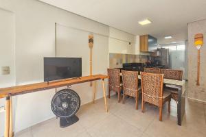 Μια τηλεόραση ή/και κέντρο ψυχαγωγίας στο F1-Pe na Areia da Praia do Tombo, 2 Suites, Ar Cond, 2 Banheiros, 1 Vaga + Roupas de Cama