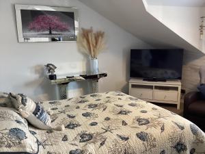 ein Schlafzimmer mit einem Bett und einem Fernseher in einem Zimmer in der Unterkunft By the Seaside in Blackpool
