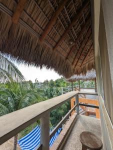 a balcony of a resort with chairs and a thatch roof at La Isla Bonita - Departamento en la Punta in Puerto Escondido +3 photos
