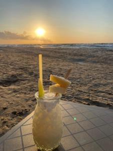 a glass jar with lemon slices in it on the beach at Beach House Mrzeżyno in Mrzeżyno +21 photos
