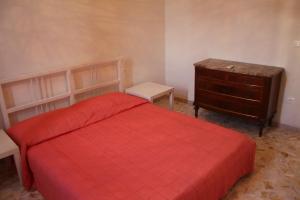 a bedroom with a red bed and a dresser at Appartamento Rifredi in Florence