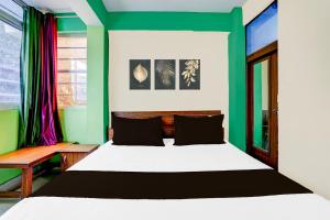 a bedroom with a white bed and green walls at SPOT ON Hotel Heritage Inn in Rājpur