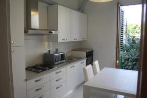 a kitchen with white cabinets and a table with a microwave at Appartamento Rifredi in Florence
